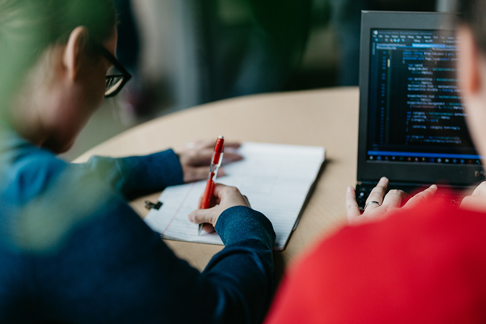 coworkers working on computer and taking notes